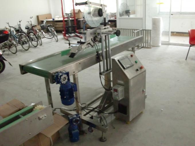 Aplicador de etiqueta de superficie plana con adhesivo autoadhesivo sobre mesa con obxectos de alimentación da máquina de paxinado